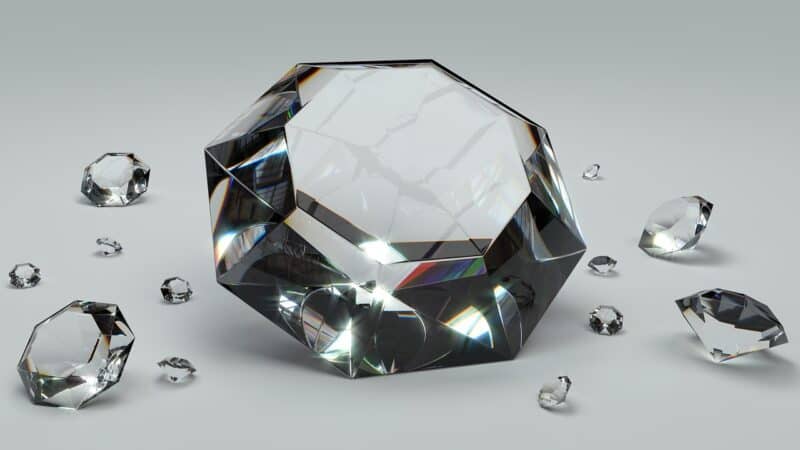 Verschiedengroße Diamanten und Brillanten auf weißer Oberfläche angeordnet